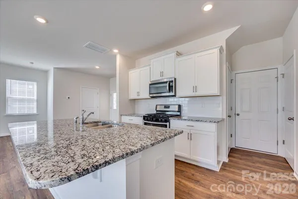 a kitchen with sink stove and refrigerator