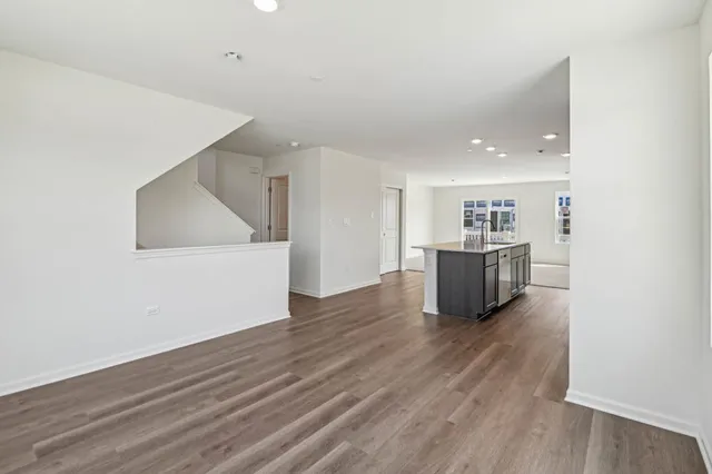 a large kitchen with wooden floor and stainless steel appliances