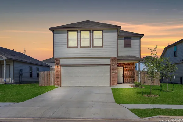 a front view of a house with a yard and garage