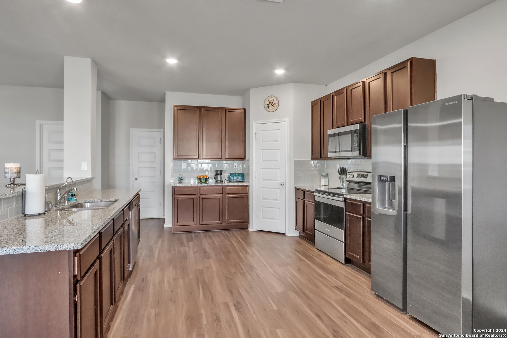 2425 Marty Way Seguin, TX 78155 - Photo 11 of 22 a kitchen with kitchen island granite countertop stainless steel appliances a sink refrigerator stove and oven