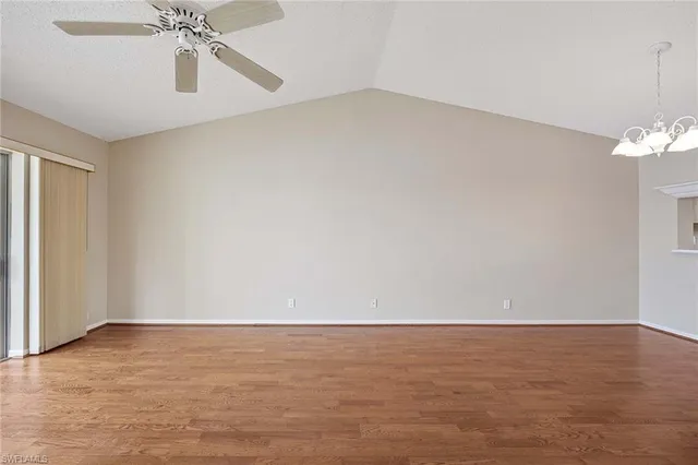 a view of an empty room with a chandelier fan