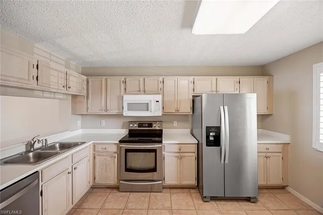a kitchen with stainless steel appliances a refrigerator sink and stove