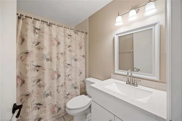 a bathroom with a sink a toilet and shower curtain
