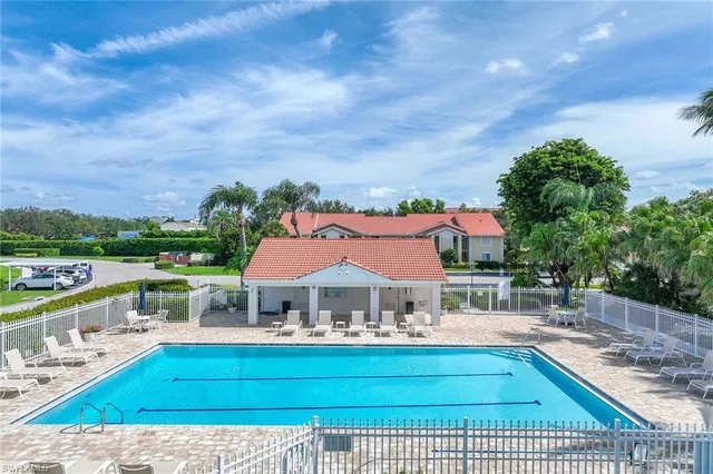 a view of a house with pool and chairs