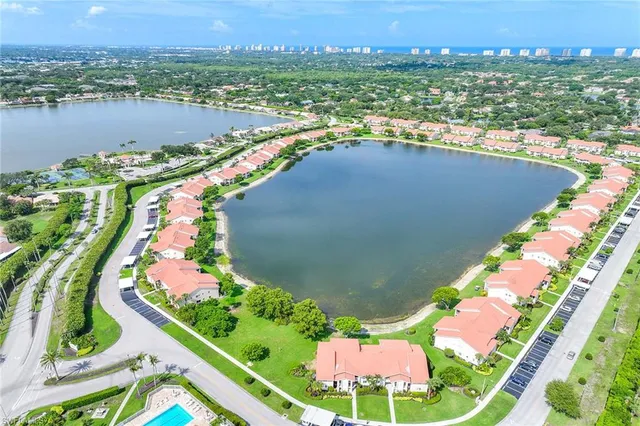 an aerial view of residential houses with outdoor space and lake view