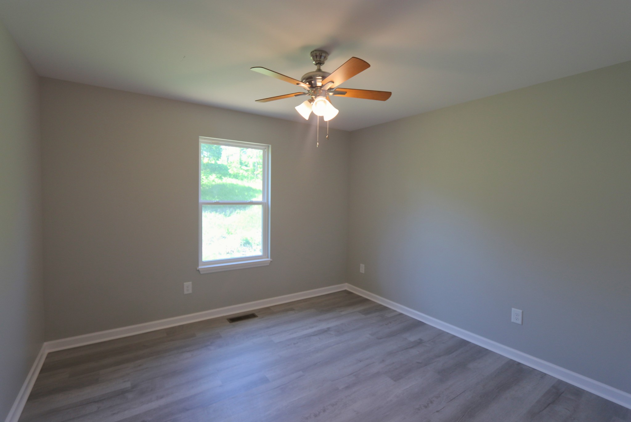 512 Highland Park Road Red Boiling Springs, TN 37150 - Photo 14 of 18 an empty room with wooden floor fan and windows