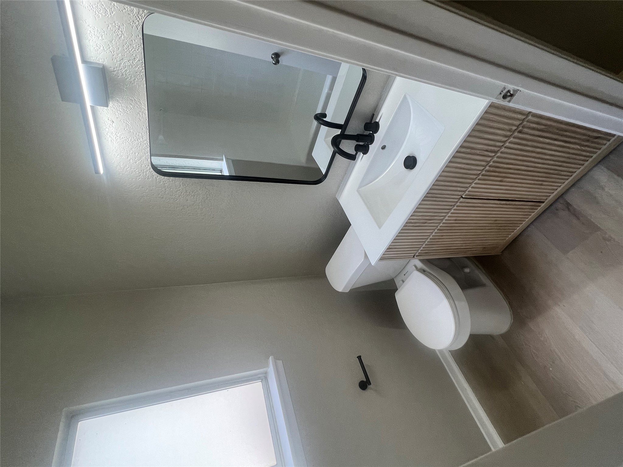 4620 Button Bend Road Austin, TX 78744 - Photo 11 of 22 A well-appointed bath features a modern vanity with elegant textured cabinetry and resilient flooring.