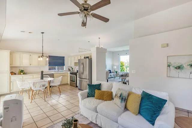 a living room with furniture kitchen view and a chandelier