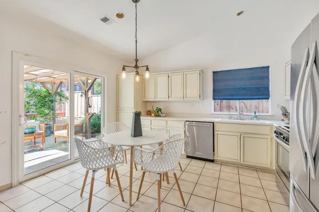 a kitchen with a stove a sink and chandelier