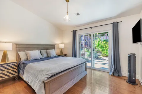 a large bed sitting in a bedroom next to a window with a flat screen tv