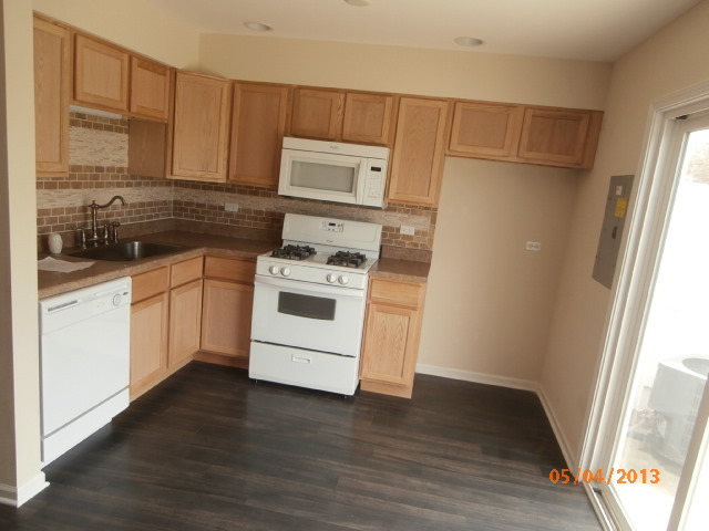 334 Rodenburg Road Roselle, IL 60172 - Photo 7 of 14 a kitchen with a white stove top oven and white cabinets