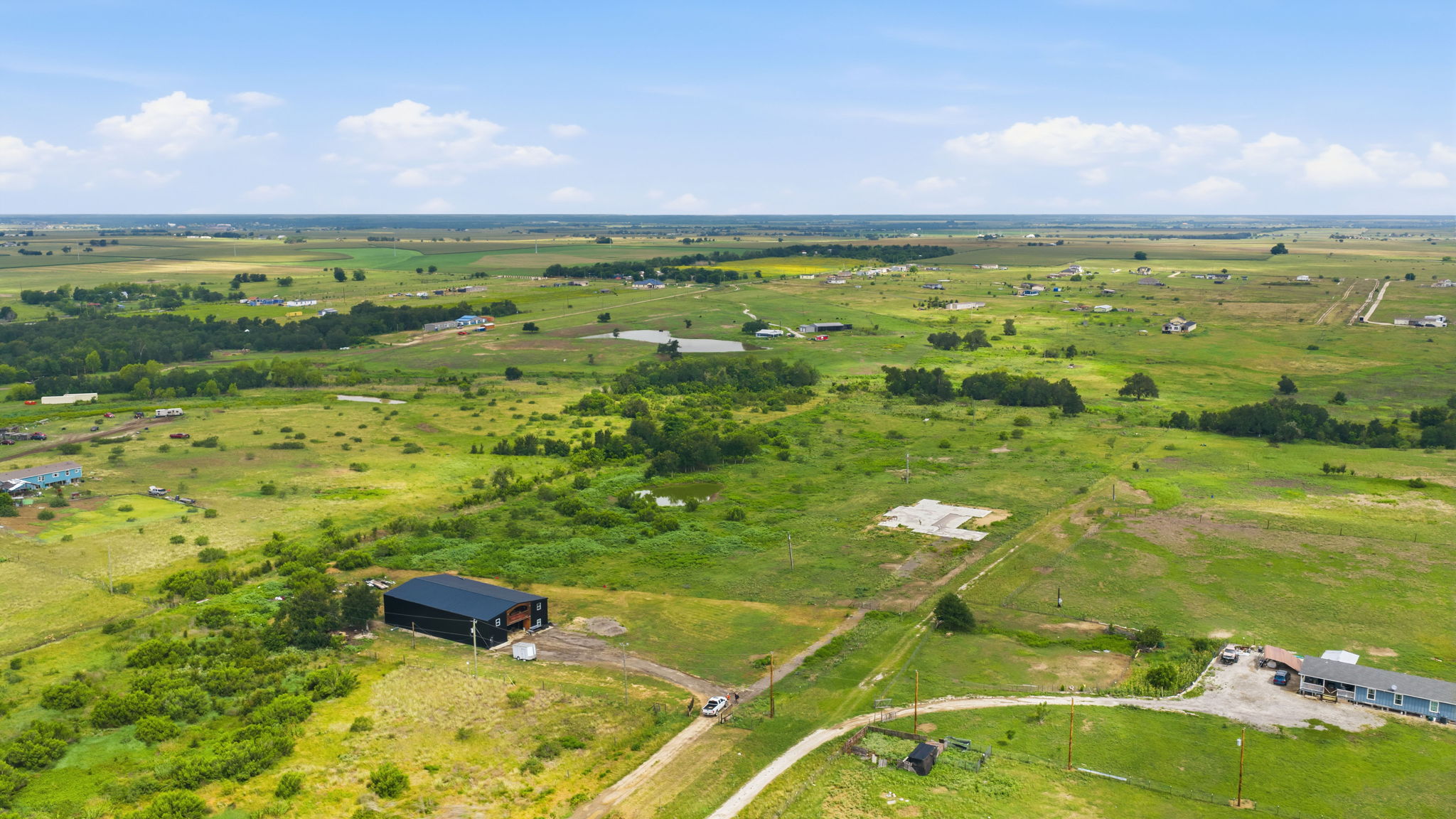 1701 County Road 466 Elgin, TX 78621 - Photo 18 of 24 Vast green acreage offers expansive views and development potential with existing structures and clearings.