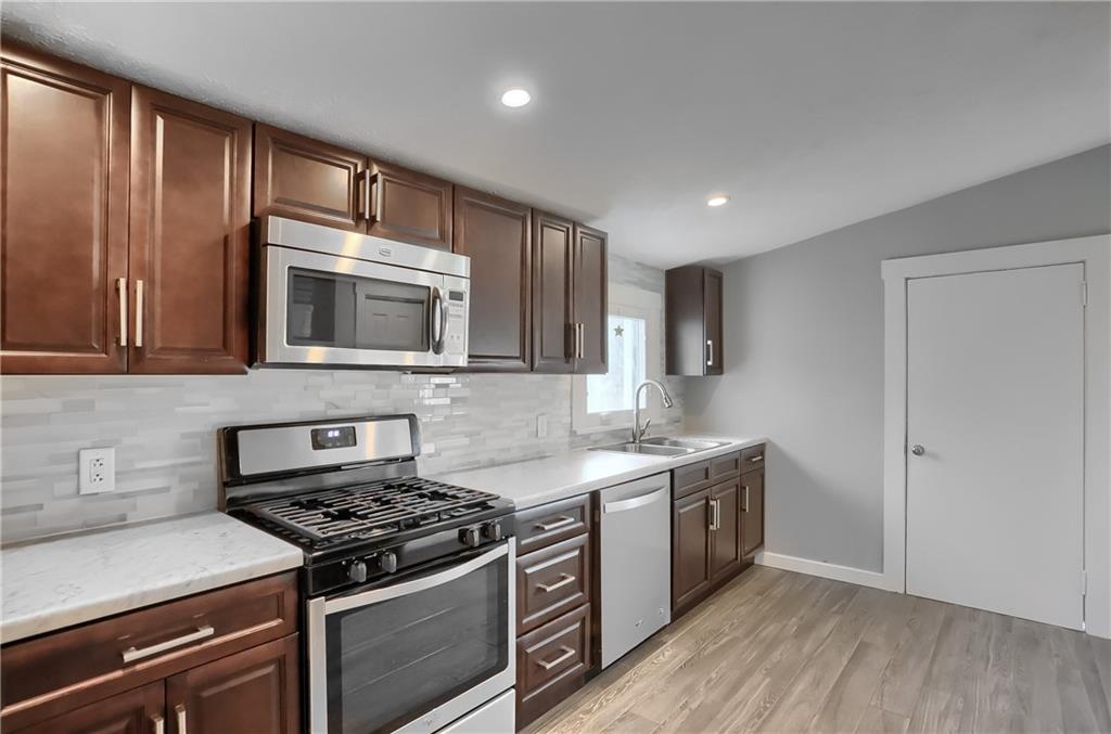 549 Sawmill Run Road Butler, PA 16001 - Photo 10 of 25 a kitchen with stainless steel appliances a sink dishwasher a stove and a microwave oven on granite countertops