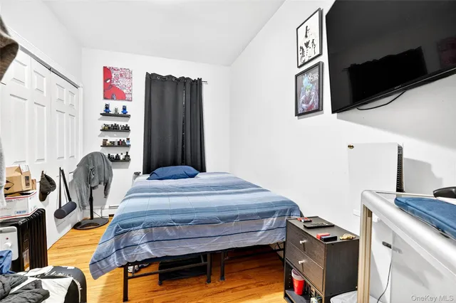 a bedroom with bed and wooden floor