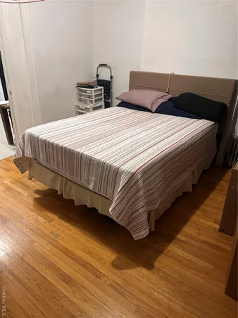 a bedroom with bed and wooden floor