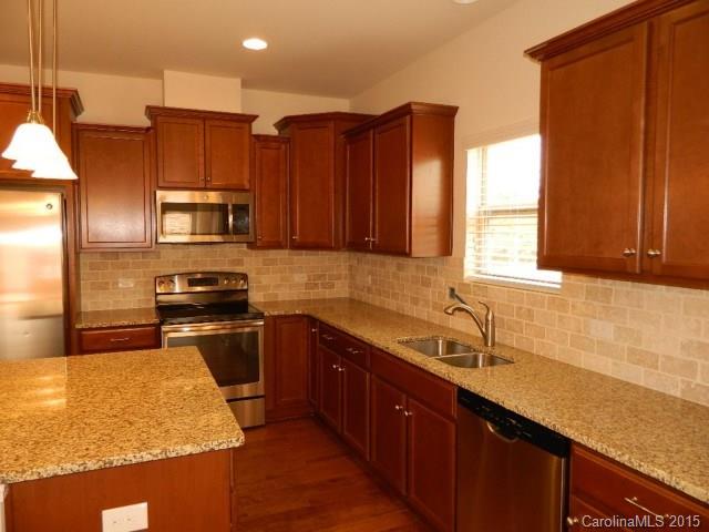 1513 Spring Blossom Trail, Unit SITE 47 Fort Mill, SC 29708 - Photo 3 of 11 a kitchen with stainless steel appliances granite countertop a sink a stove and a refrigerator