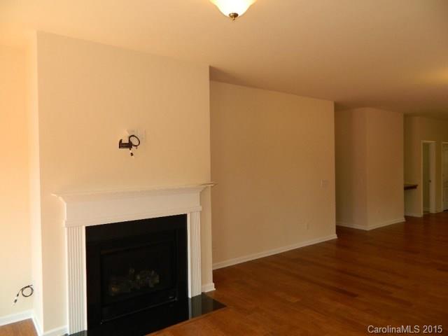 1513 Spring Blossom Trail, Unit SITE 47 Fort Mill, SC 29708 - Photo 5 of 11 a view of an empty room with wooden floor and a fireplace