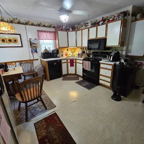 a kitchen with stainless steel appliances a stove a sink dishwasher a microwave oven with a dining table and chairs