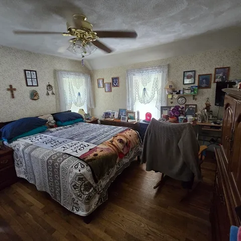 a bedroom with a bed lamps dresser and window