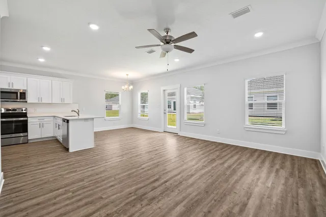 a view of an empty room with wooden floor