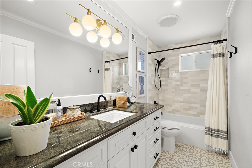 8741 La Roca Avenue Fountain Valley, CA 92708 - Photo 29 of 50 Guest Bathroom with granite countertop, chic title flooring, tub/shoer combo with subway tile surround