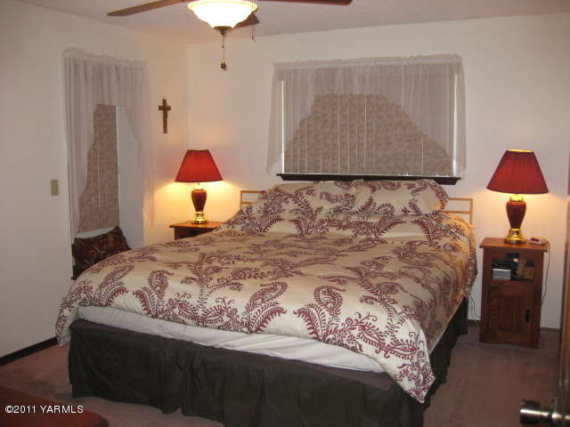 210 White Road Yakima, WA 98901 - Photo 14 of 63 a bedroom with a bed and a lamp