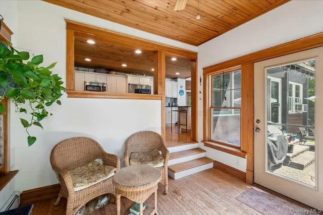 a living room with patio furniture and potted plants