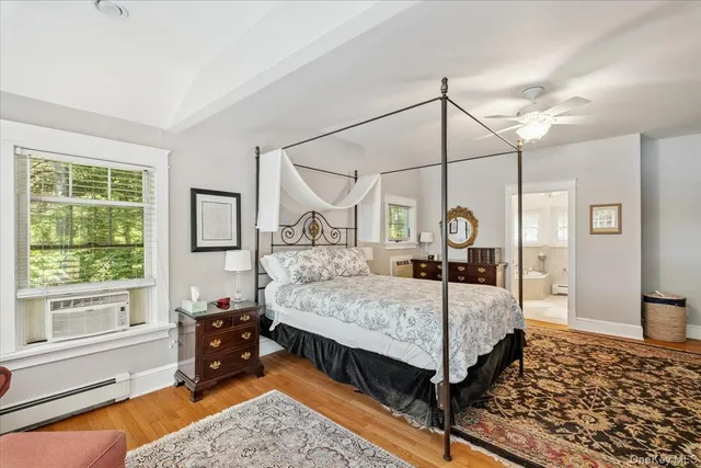 a bedroom with a bed a dresser and next to a window