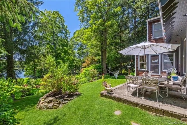 a view of a chair and table in backyard of the house