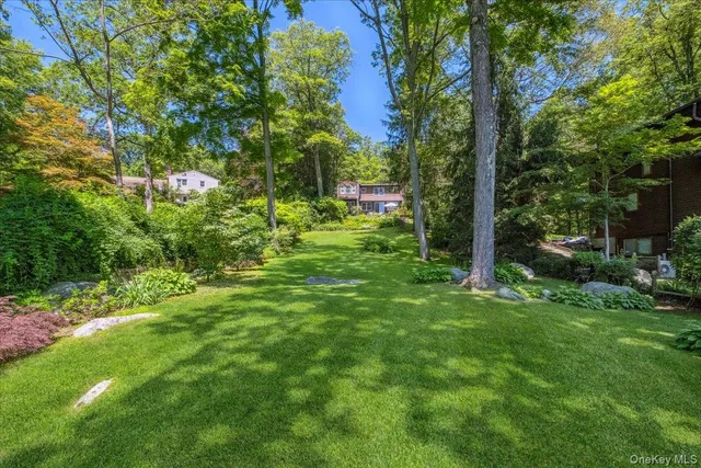 a view of a house with a yard and tree s