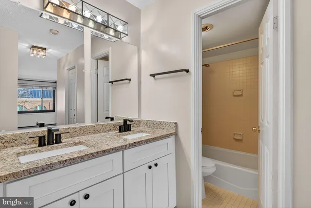 a bathroom with a granite countertop sink mirror and double