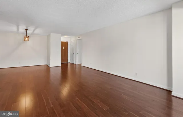 a view of an empty room with wooden floor