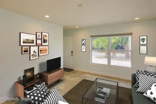 a living room with furniture a flat screen tv and a window