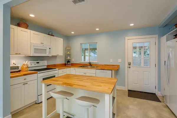 a kitchen with stainless steel appliances granite countertop a stove a sink and a refrigerator
