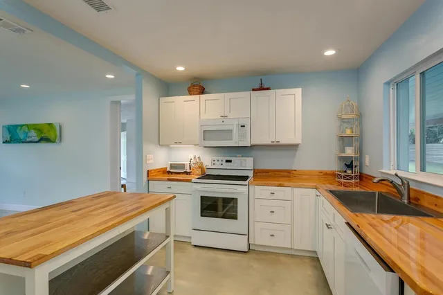a kitchen that has a sink a stove and cabinets