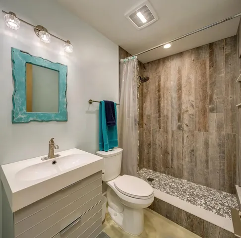 a bathroom with a toilet a sink and a mirror