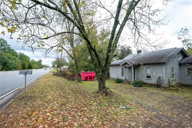 a view of a house with a yard and large tree