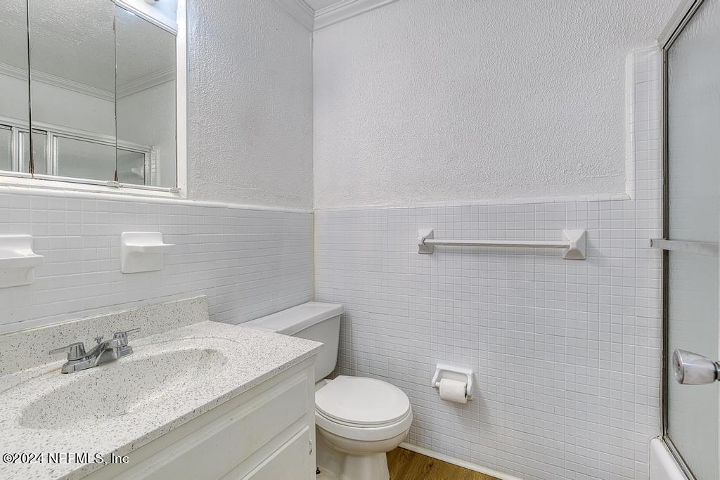 1768 El Camino Road, Unit 7 Jacksonville, FL 32216 - Photo 27 of 43 a bathroom with a granite countertop toilet a sink and a mirror