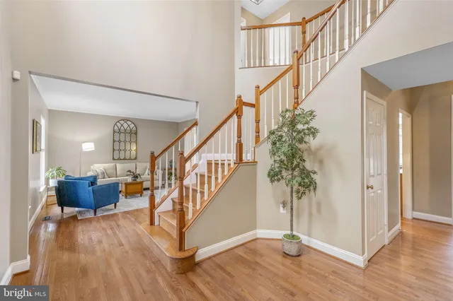 a kitchen with stainless steel appliances granite countertop a refrigerator a stove and a sink with wooden floor