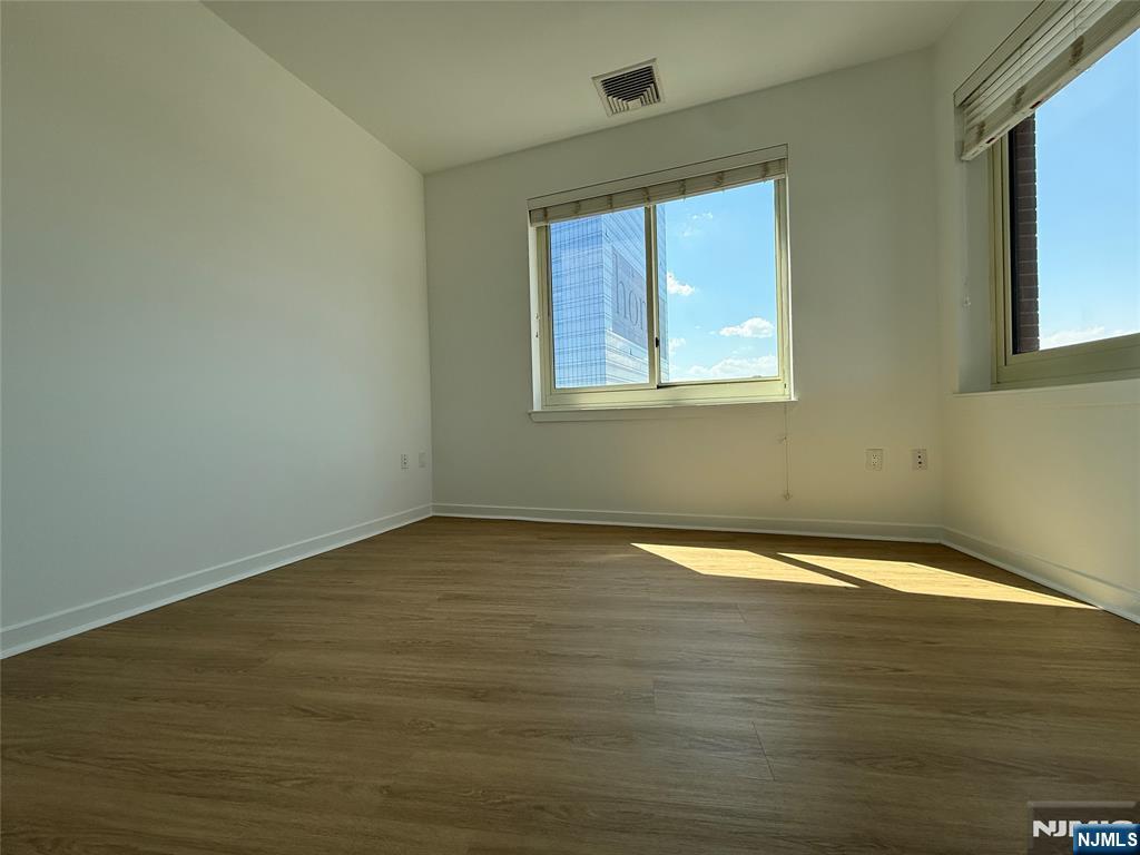 2050 North Central Road, Unit 710 Fort Lee, NJ 07024 - Photo 9 of 21 a view of an empty room with wooden floor and a window