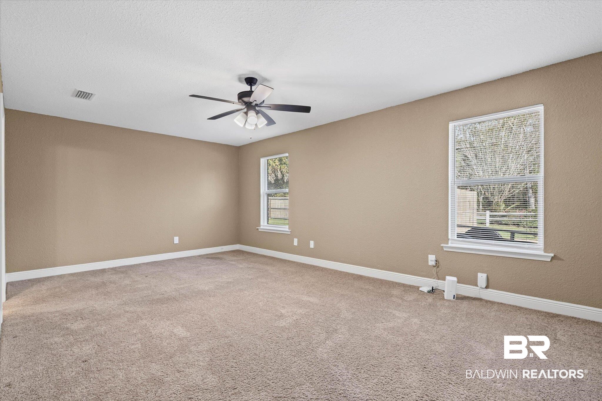 101 Washington Boulevard Foley, AL 36535 - Photo 12 of 32 Empty room with light carpet, a ceiling fan, and a textured ceiling
