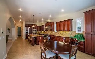 a dining hall with stainless steel appliances a dining table and chairs