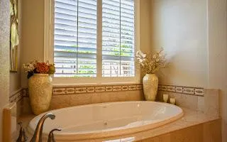 a bath tub sitting in a bathroom next to a window