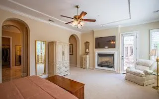 a bedroom with furniture a fireplace and a chandelier