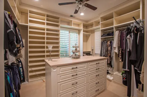 a view of walk in closet with clothes and shoes