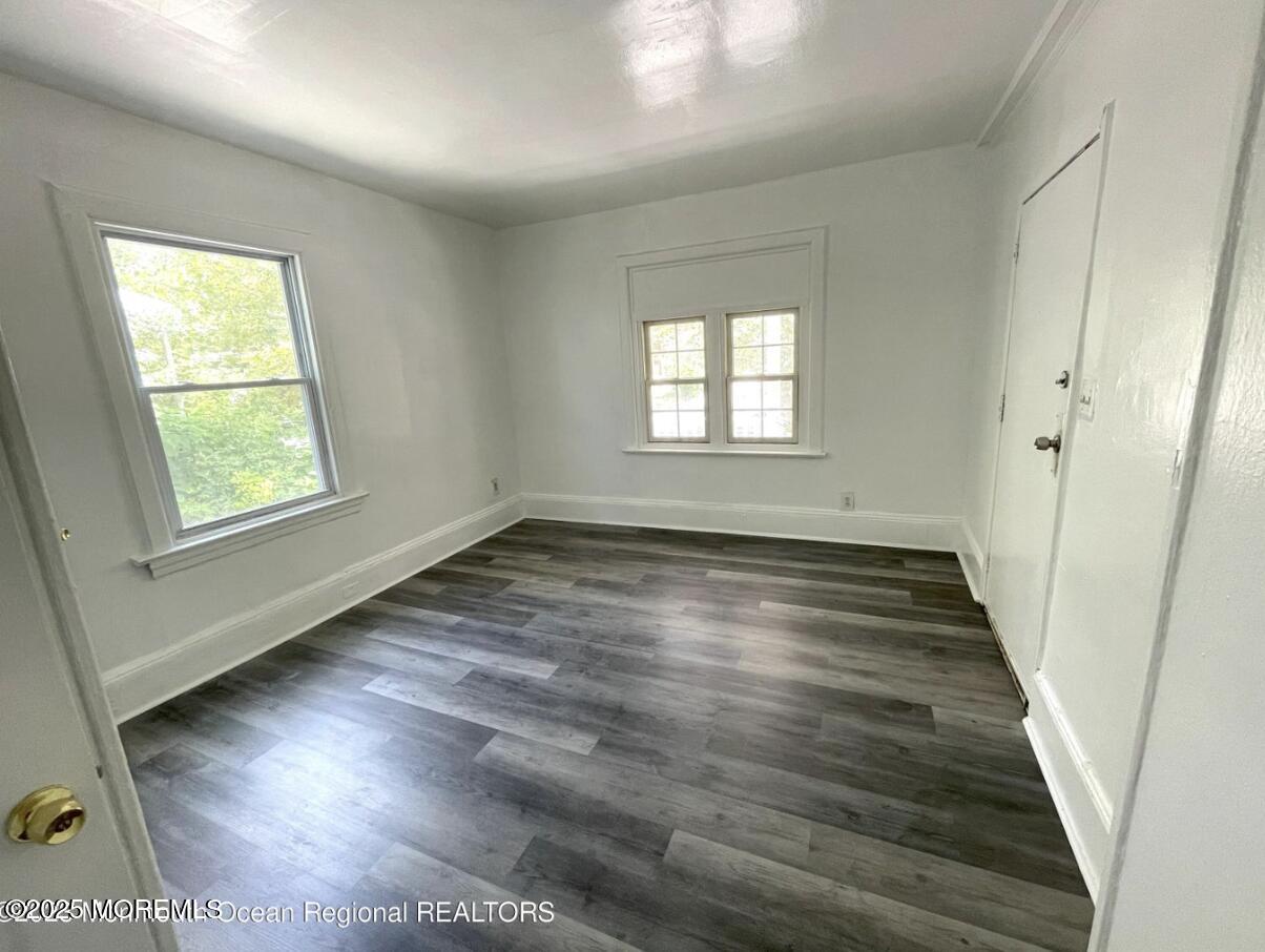 1027 Monroe Avenue, Unit 1 Asbury Park, NJ 07712 - Photo 2 of 10 an empty room with wooden floor and windows