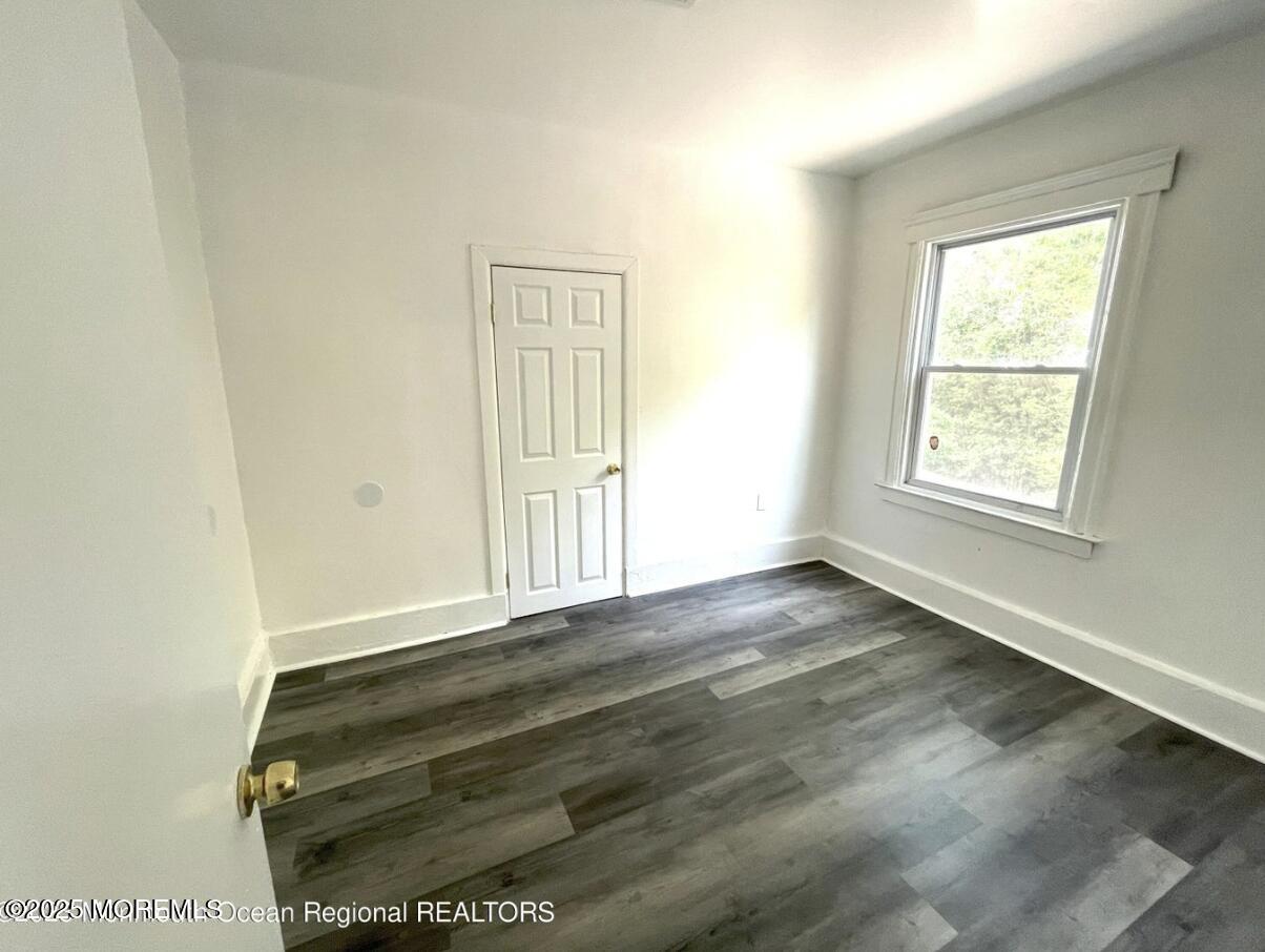 1027 Monroe Avenue, Unit 1 Asbury Park, NJ 07712 - Photo 6 of 10 an empty room with wooden floor and windows