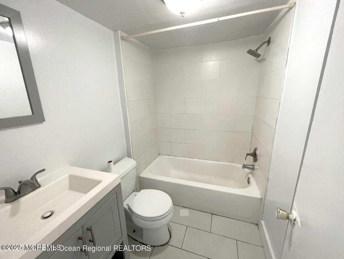 1027 Monroe Avenue, Unit 1 Asbury Park, NJ 07712 - Photo 8 of 10 a bathroom with a sink a toilet and shower