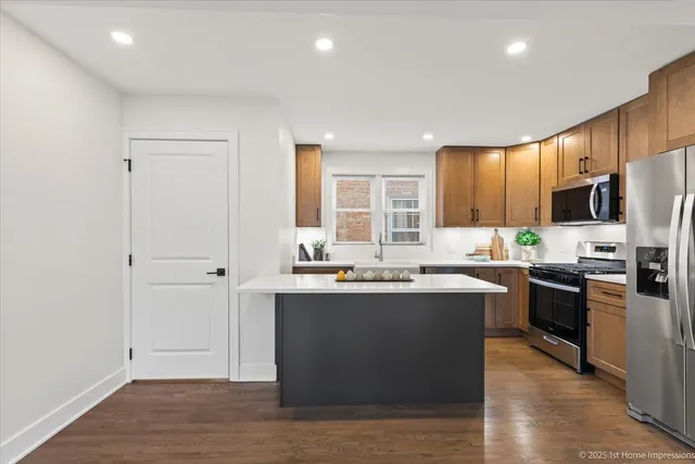 a kitchen with kitchen island granite countertop wooden cabinets and stainless steel appliances