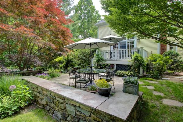 6 Glen Road Winchester, MA 01890 - Photo 27 of 30 a view of a patio with couches table and chairs under an umbrella with large trees